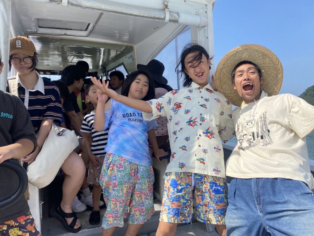 フェリーの船内で盛り上がる子どもたちとスタッフの様子