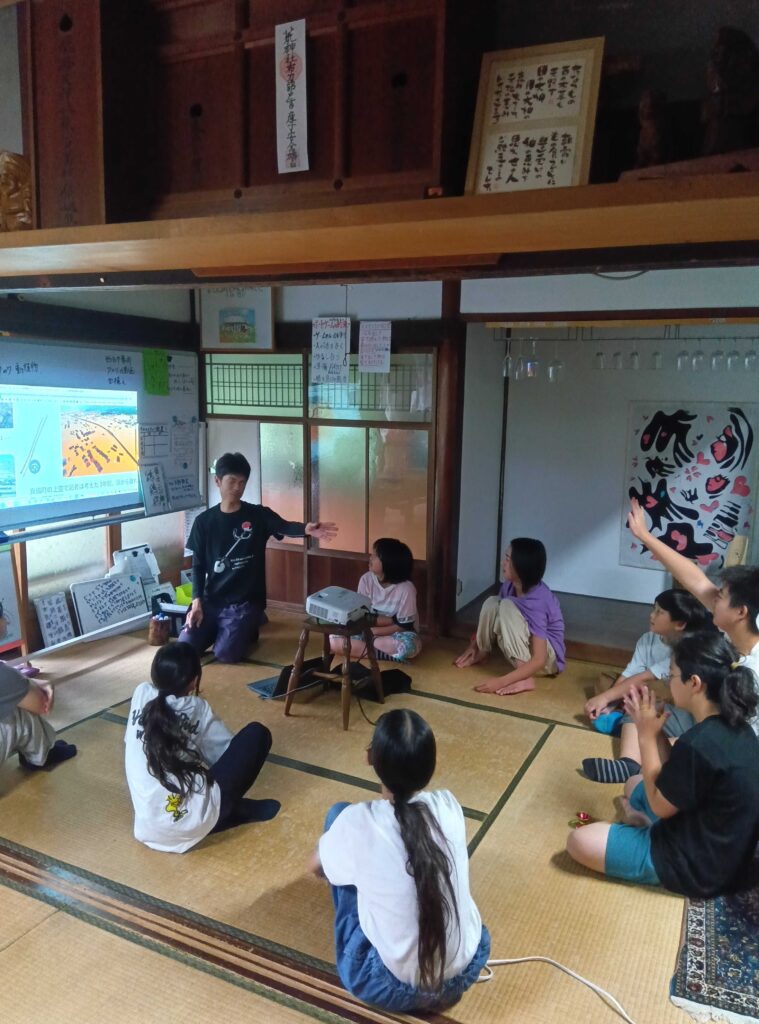 スタッフの話を車座になって聞く子どもたちの様子