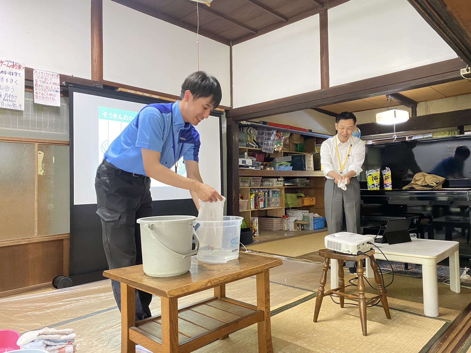 ダスキン福山さんのスタッフが雑巾の絞り方を実演する様子