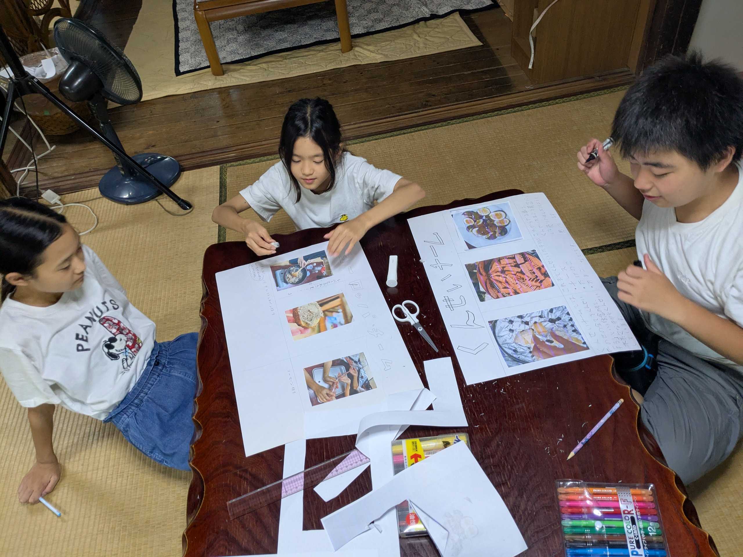 画用紙に写真や文字を貼りながらチーム紹介ポスターを作る子どもたち