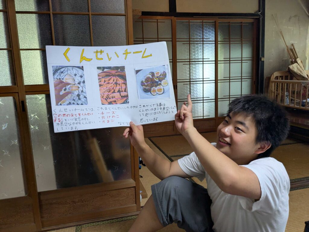 完成したチーム紹介ポスターを笑顔で掲げる子ども
