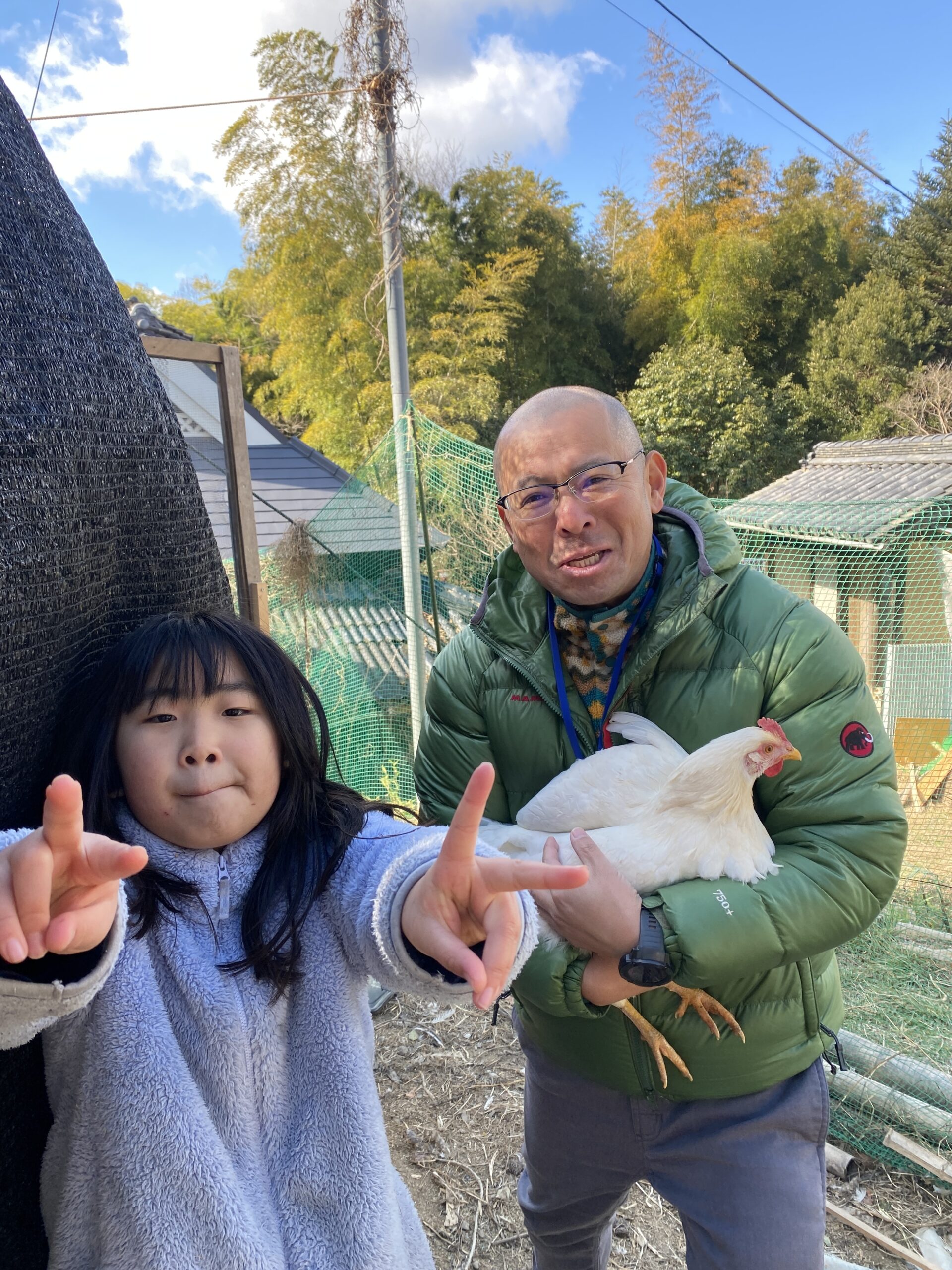ニワトリと触れ合う見学者の様子