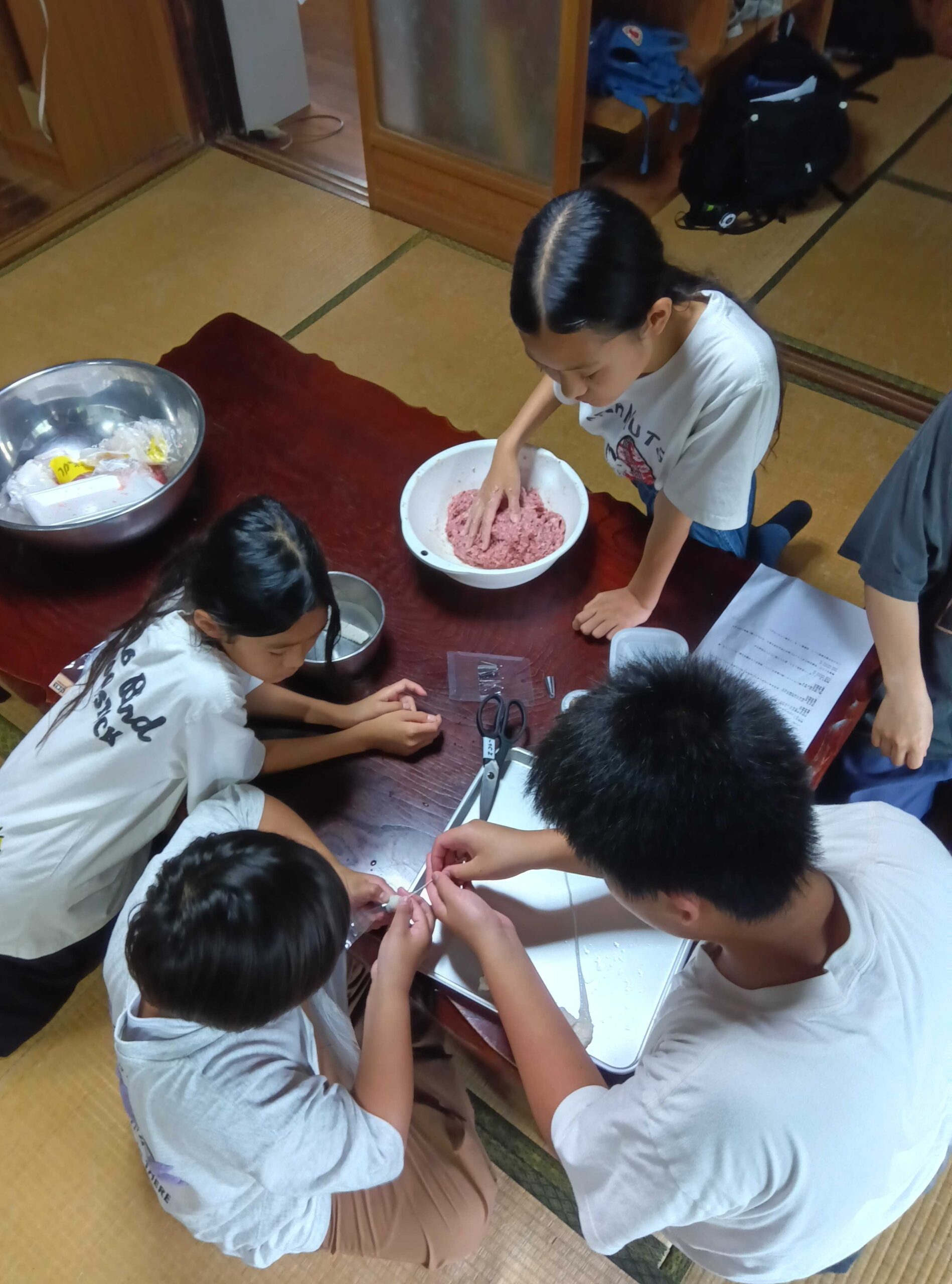 みんなでソーセージを腸に詰める様子
