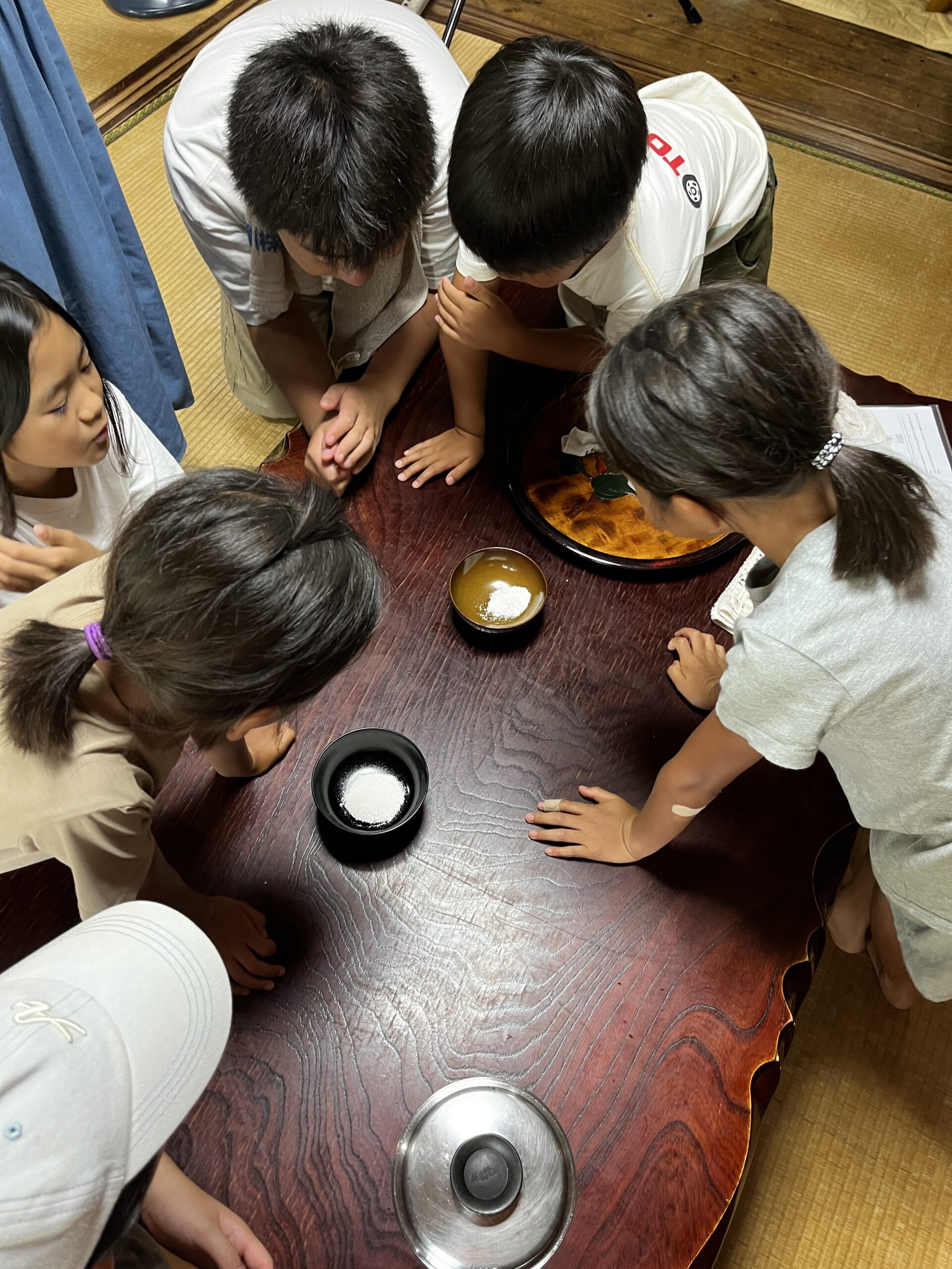 完成した塩の入った器を覗き込む子どもたちの様子