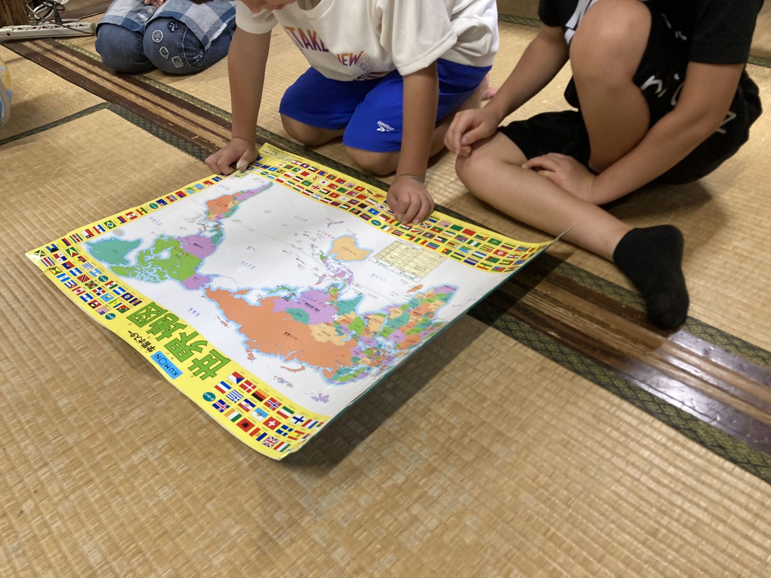 世界地図と国旗のシールを見ながらベトナムについて調べる様子