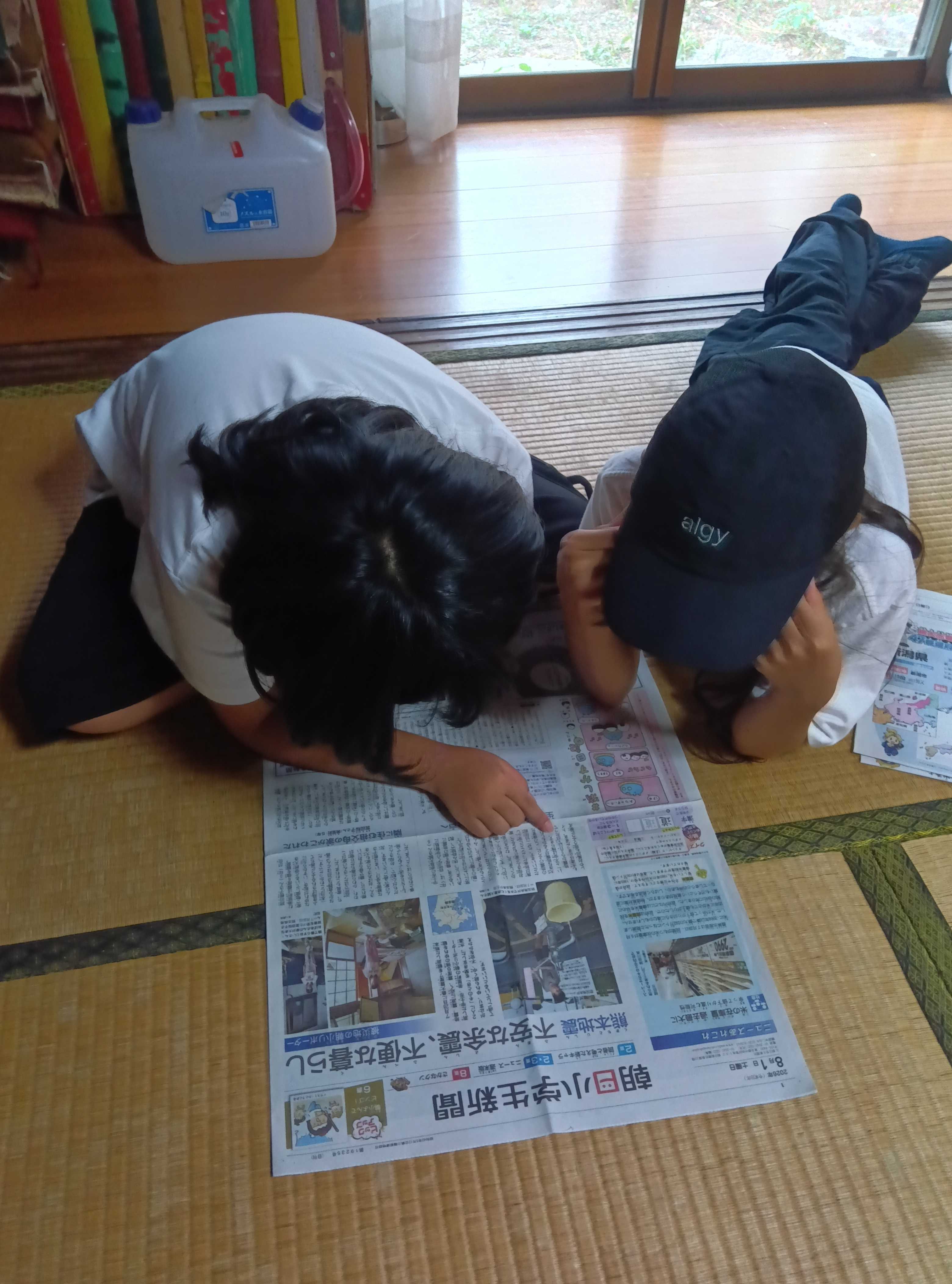 新聞を広げて読み込む子どもたちの様子