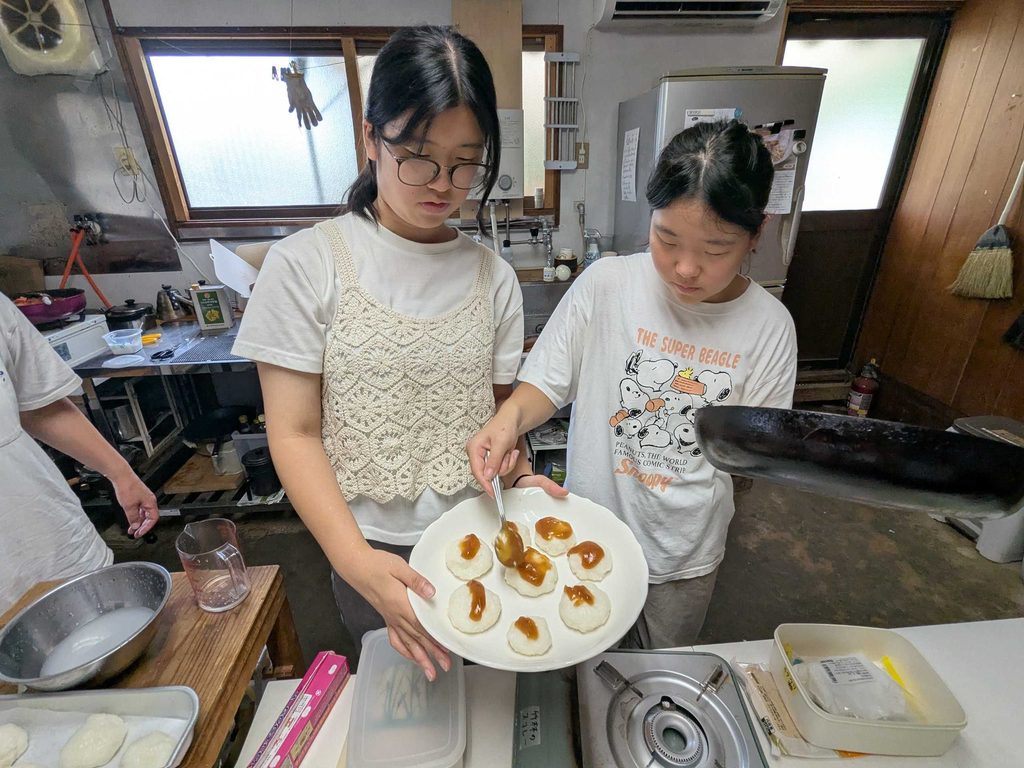 みたらし風のたれをかけたおもちを見せる参加者