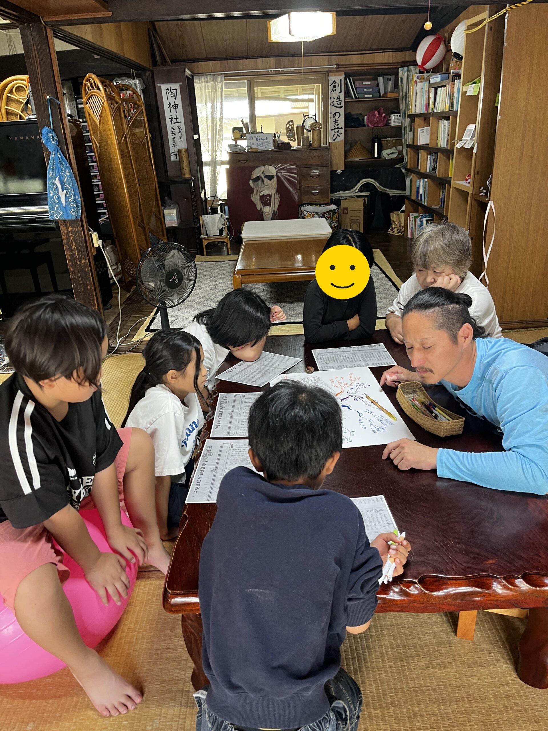 学びの木を見ながら話し合う小学部の子どもたち(1人、顔にスタンプ加工)
