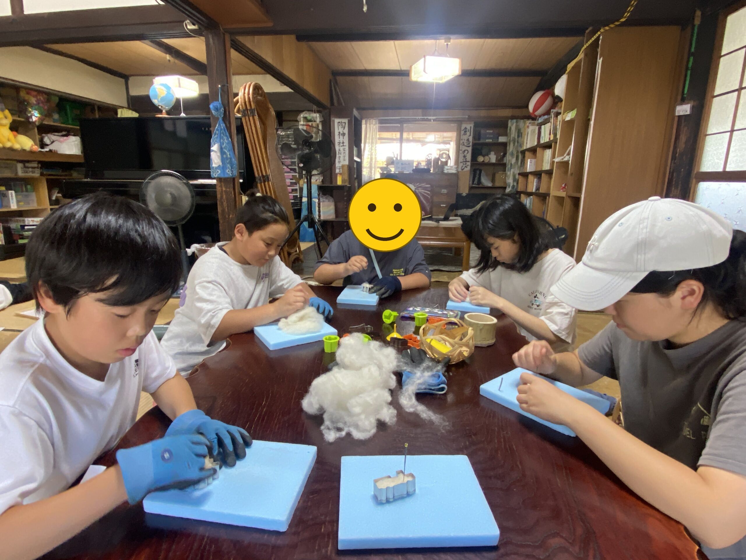 羊毛を使った作品づくりに取り組む子どもたち(一部、顔にスタンプ加工)