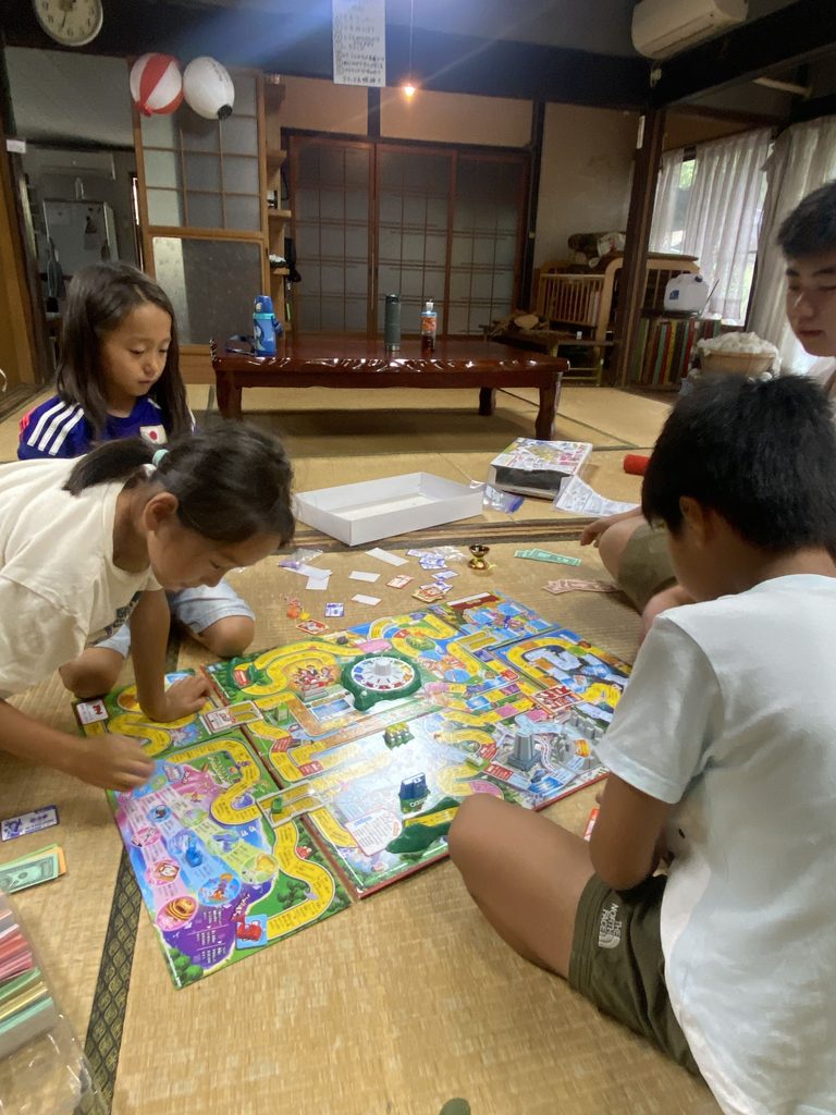 人生ゲームで盛り上がる子どもたち