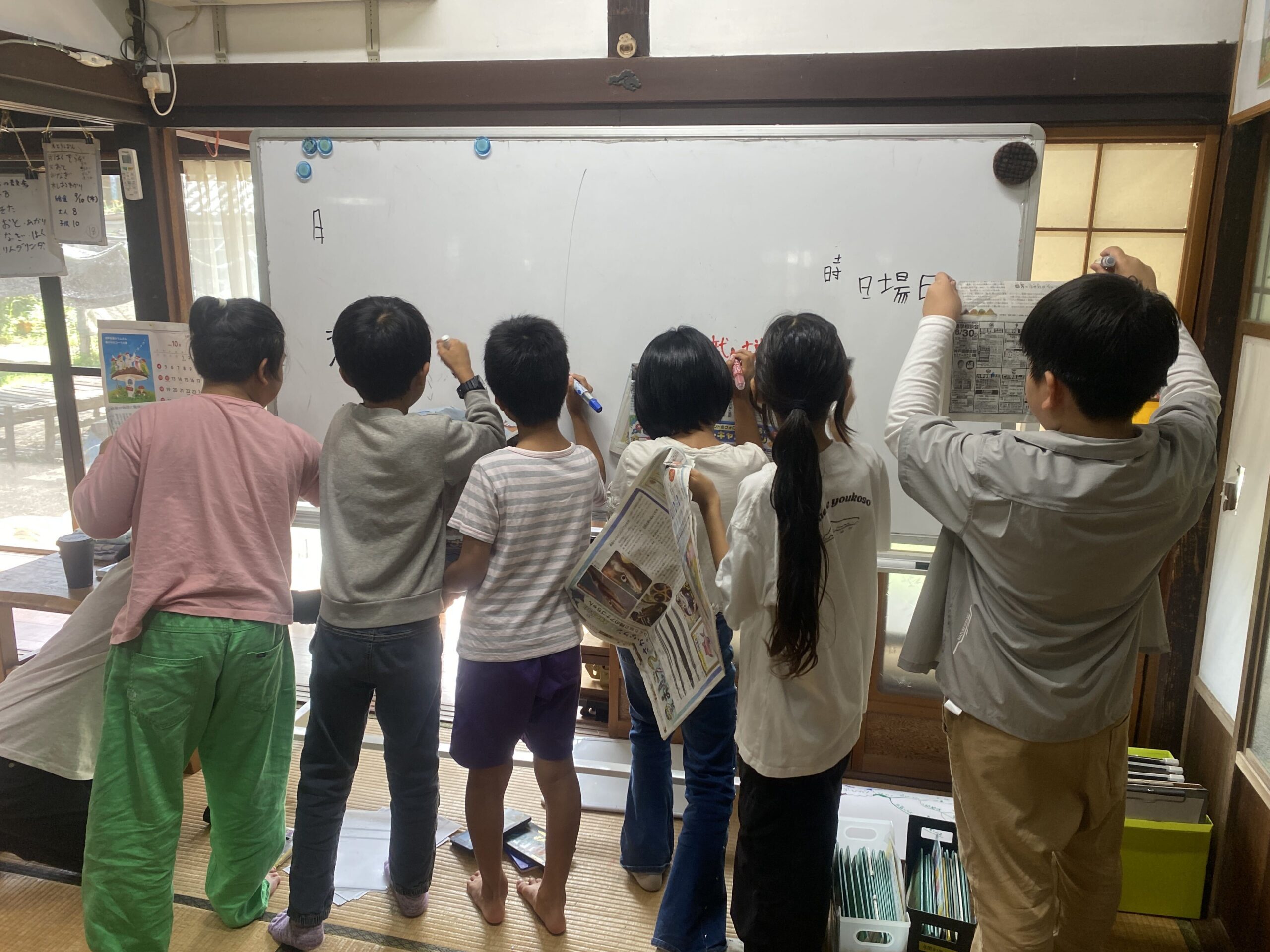 チーム対抗でホワイトボードに漢字を書き出す子どもたち