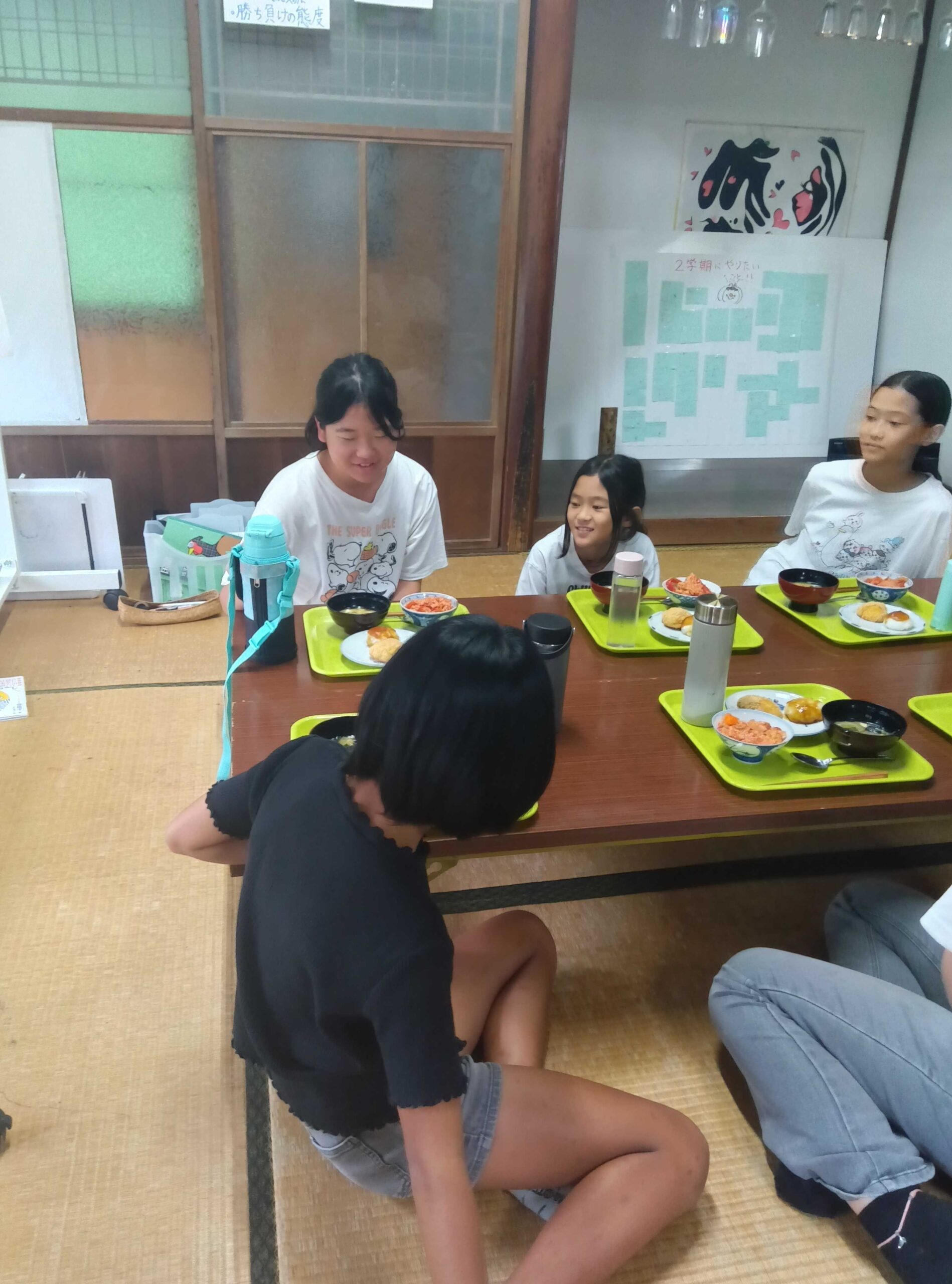 出来上がった料理を前に笑顔で集まる子どもたち