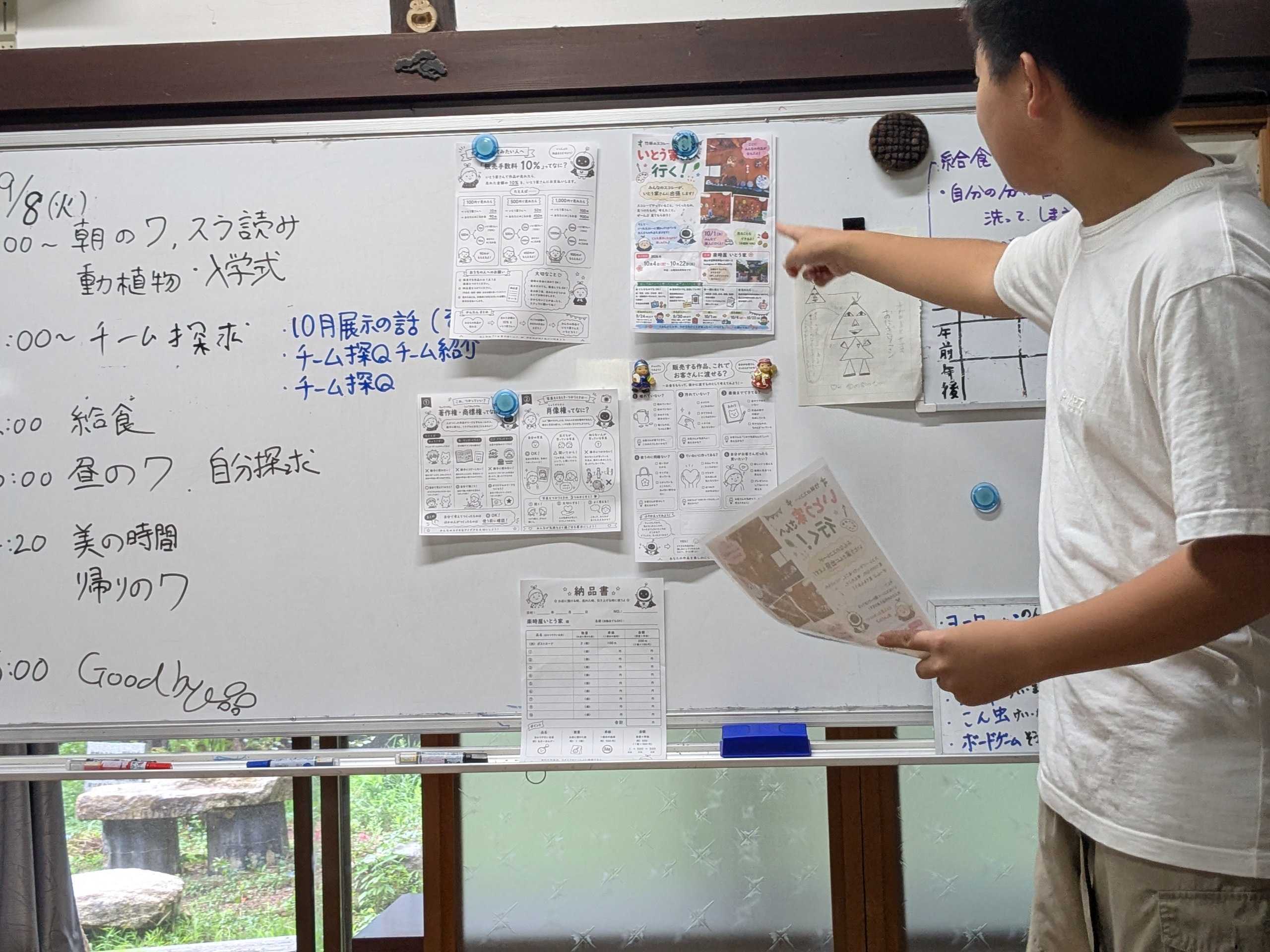 展示に関するプリントを使って説明するスタッフ
