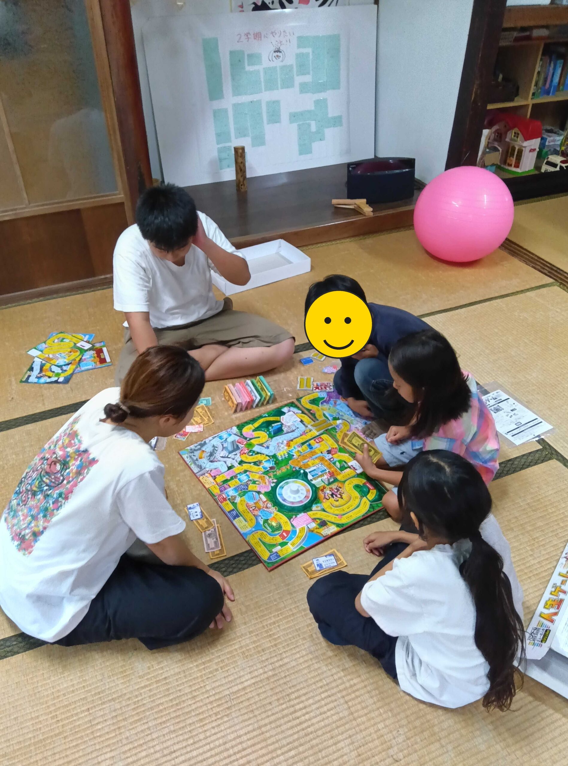人生ゲームで盛り上がる子どもたちとスタッフの様子(一部お子さんの顔を加工しています)