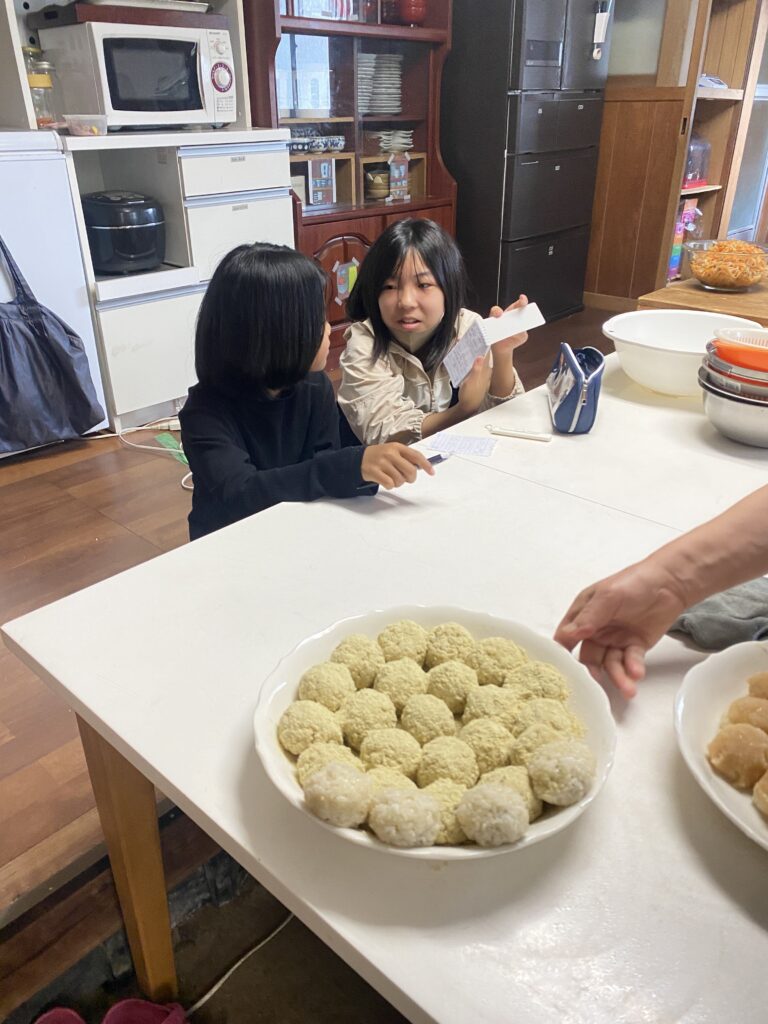 大皿に並んだ丸いお菓子と、テーブルを囲む子どもたち