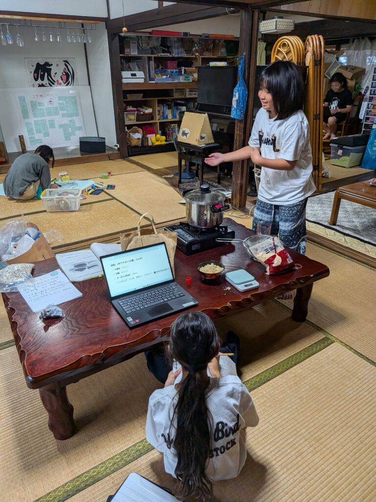 ノートパソコンを前に、身ぶりを交えて話す子