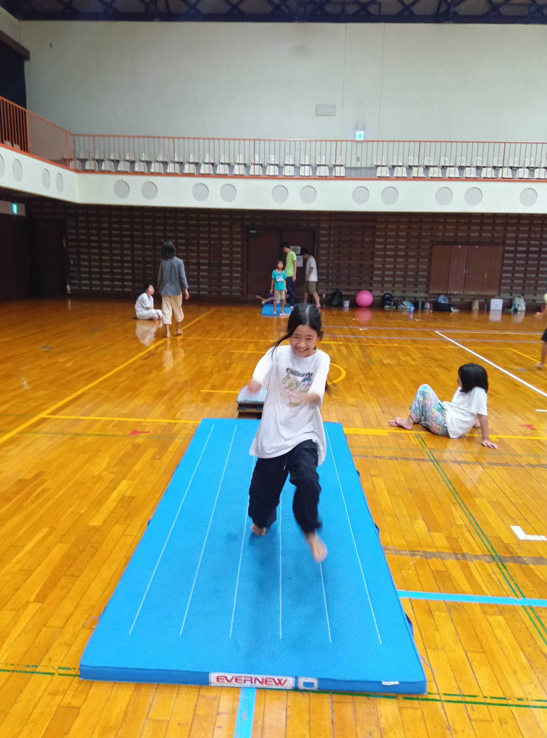 笑顔でマットに着地する子ども