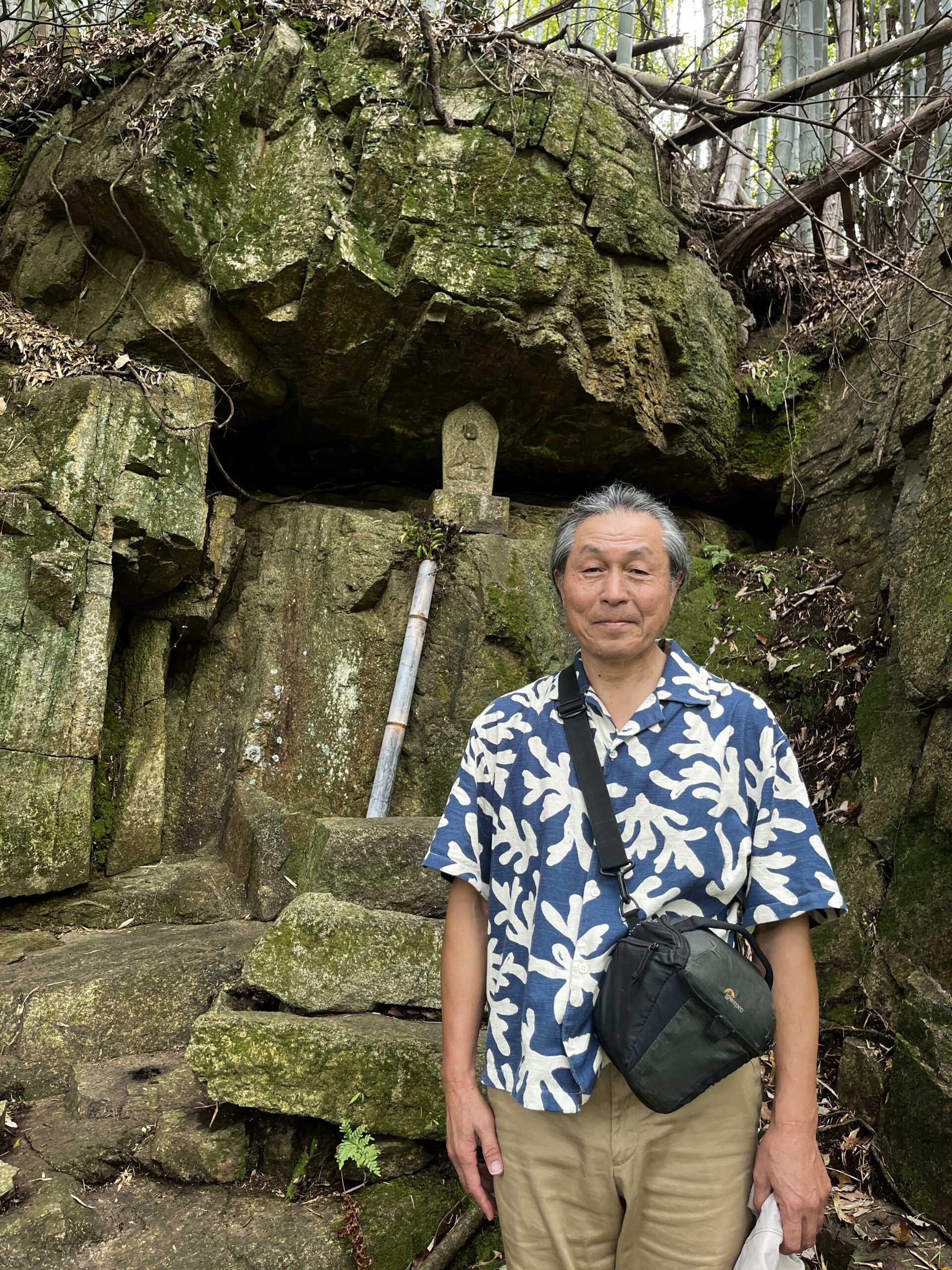 巨石ハンターの須田郡司さんが、大岩の前に立つ様子