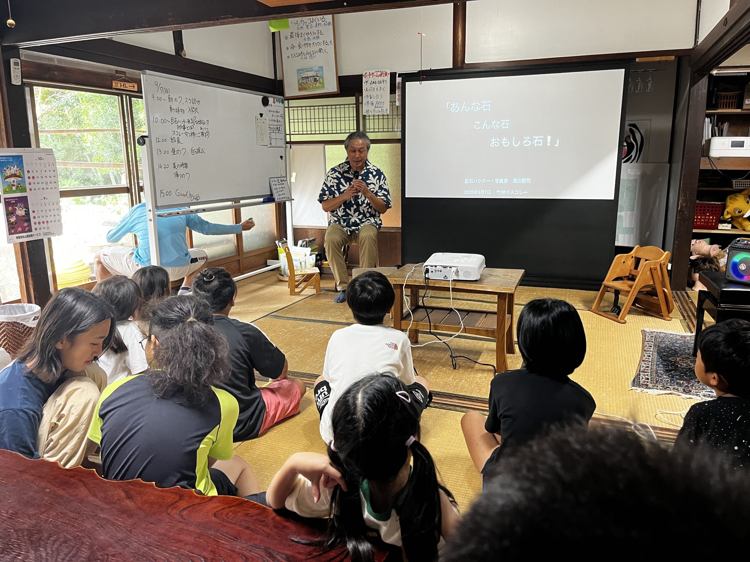須田さんが「あんな石こんな石おもしろ石」というタイトルのスライドとともに話す様子