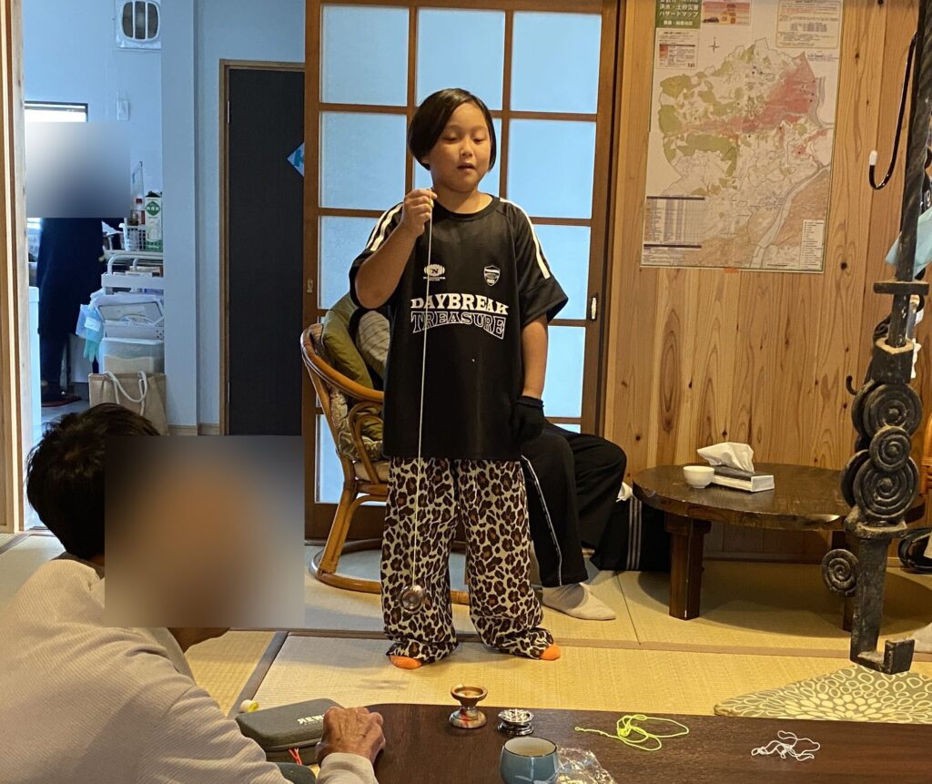 おじいちゃんたちの前で、ヨーヨーを披露する子ども