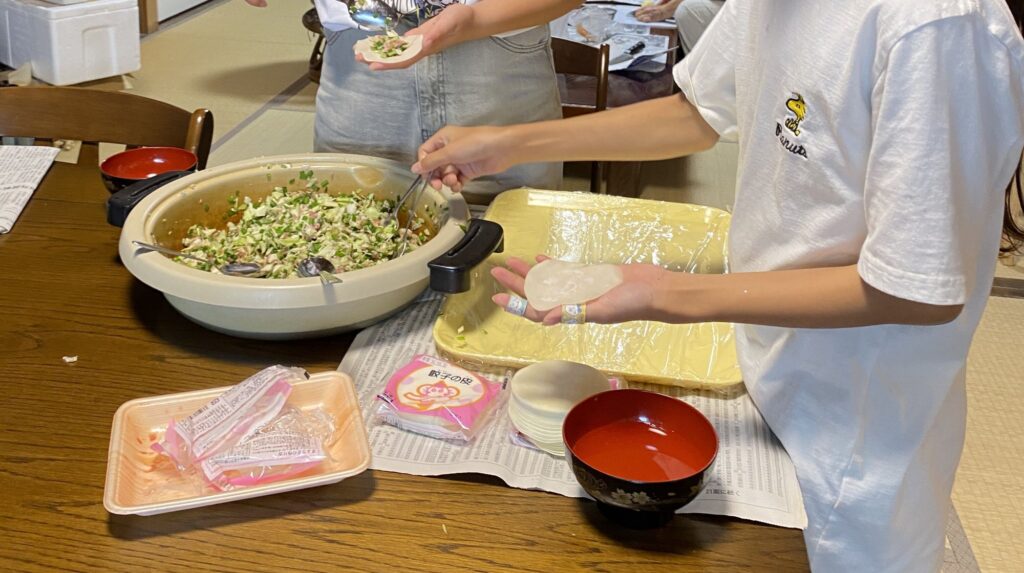 スプーンで具をのせて、餃子を包む子どもたちの手元