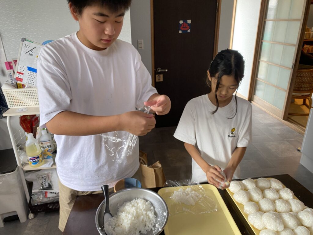 炊きあがったご飯でおにぎりを作る子どもたち