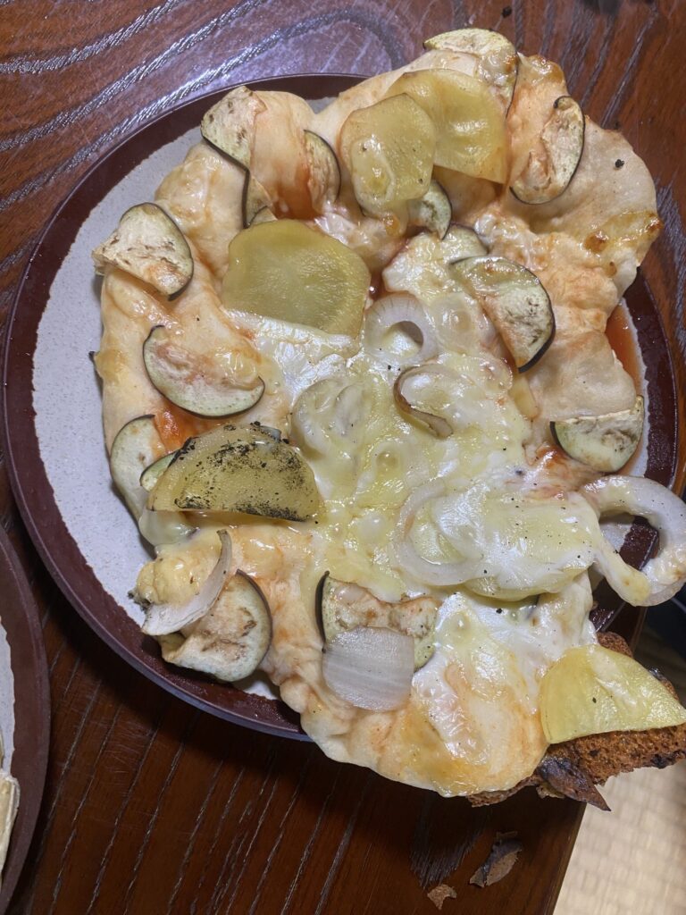 ナスやじゃがいも、玉ねぎをのせて焼きあがったピザ