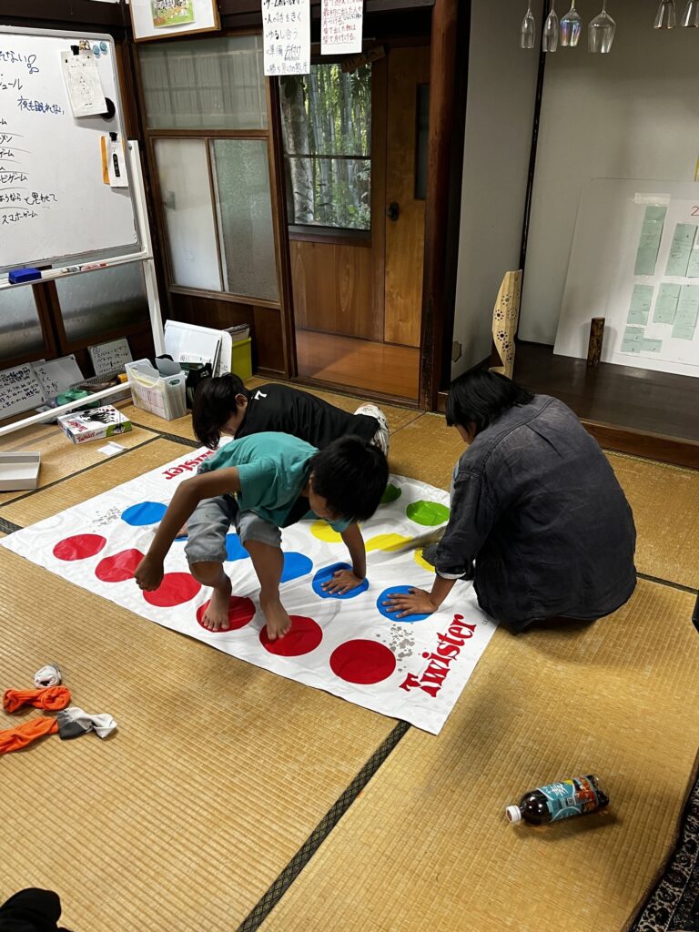 手足をのばしてツイスターゲームに挑む子どもたち