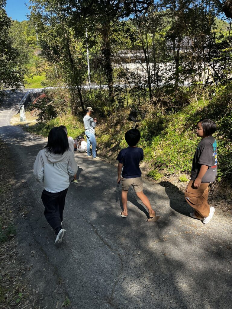 秋を感じるものを探しに、坂道を歩いていく子どもたち