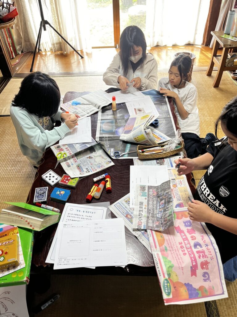 新聞記事をシートに貼り、見出しを書き写す子どもたち