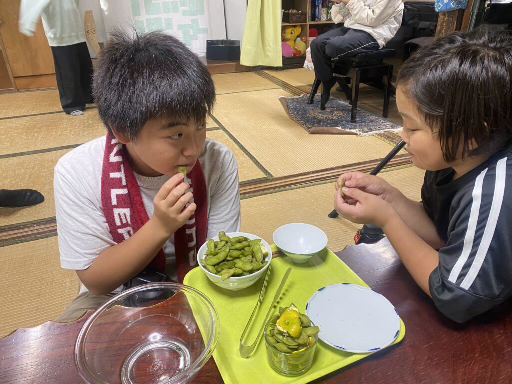 枝豆を口に運ぶ子どもたち