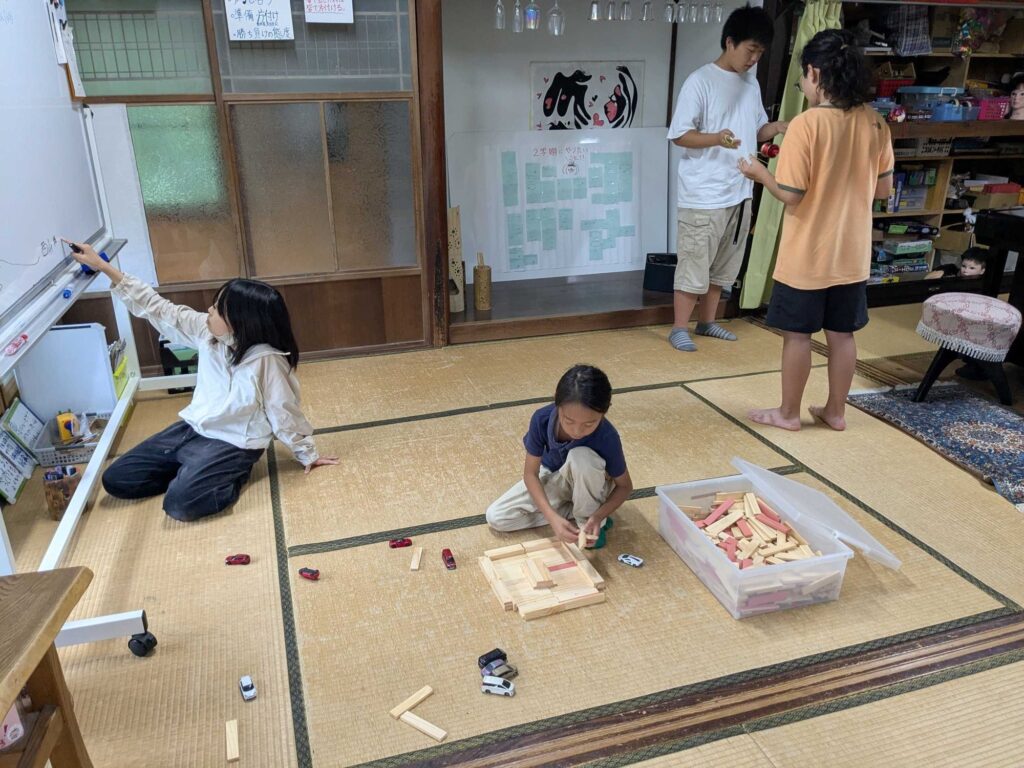 畳の上で積み木を組み立てたり、ホワイトボードに書いたりして過ごす子どもたち