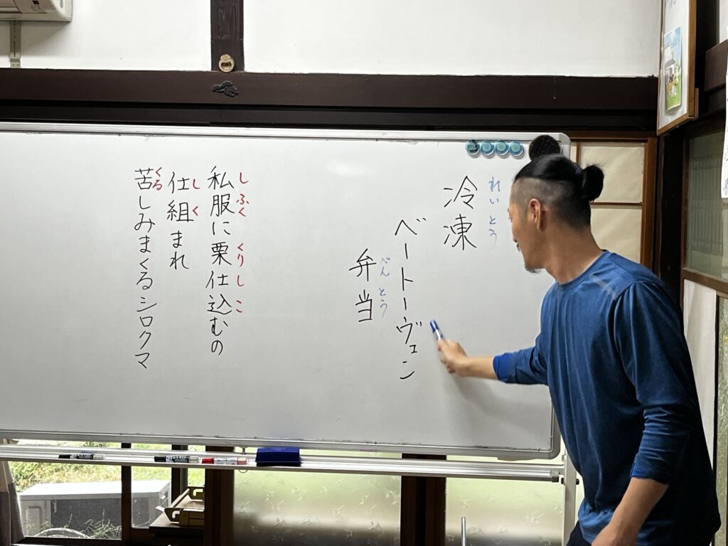 「冷凍 ベートーヴェン 弁当」などの早口言葉をホワイトボードに書くスタッフ