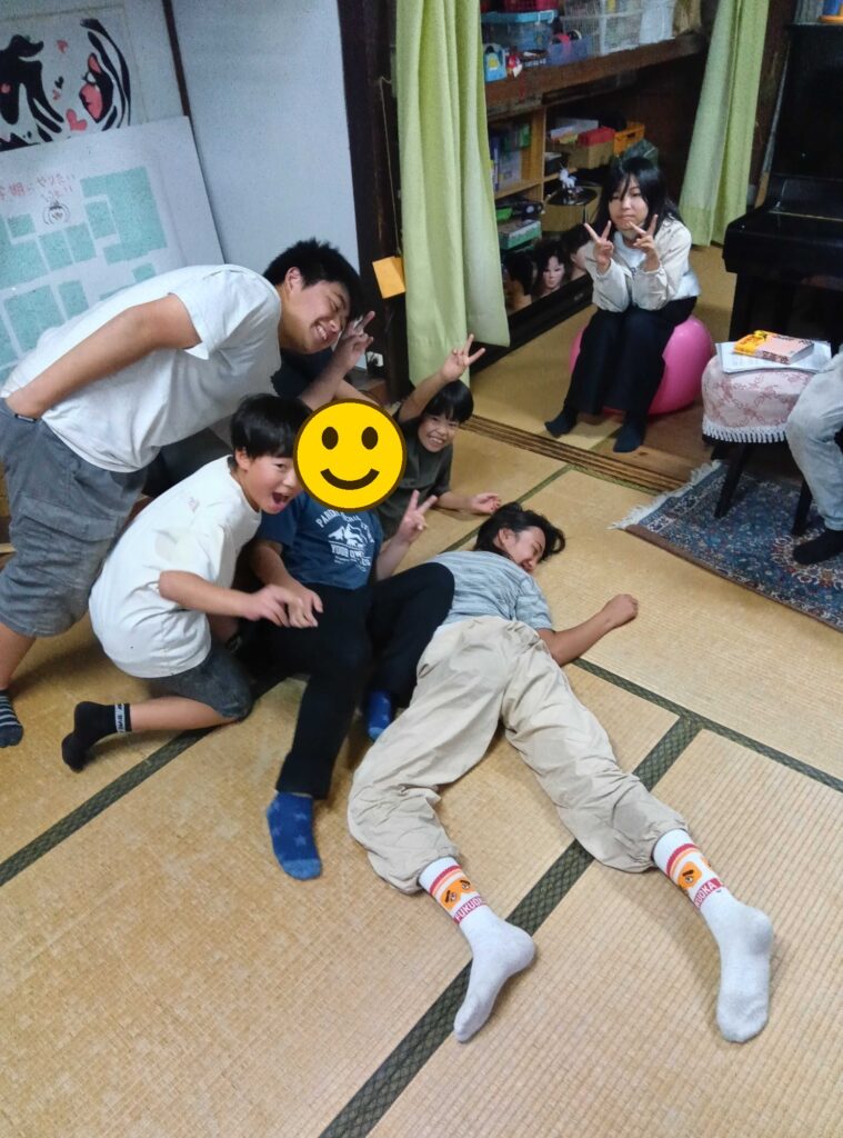 畳の上で、笑顔でポーズをとる子どもたち