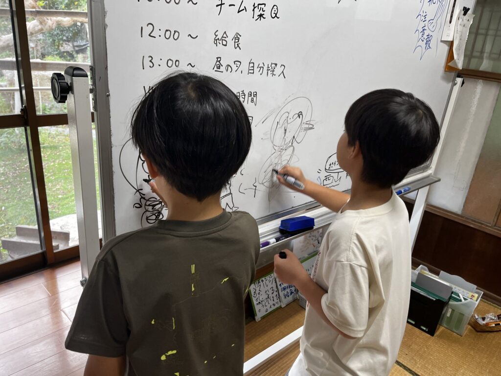 ホワイトボードに絵を描く子どもたち