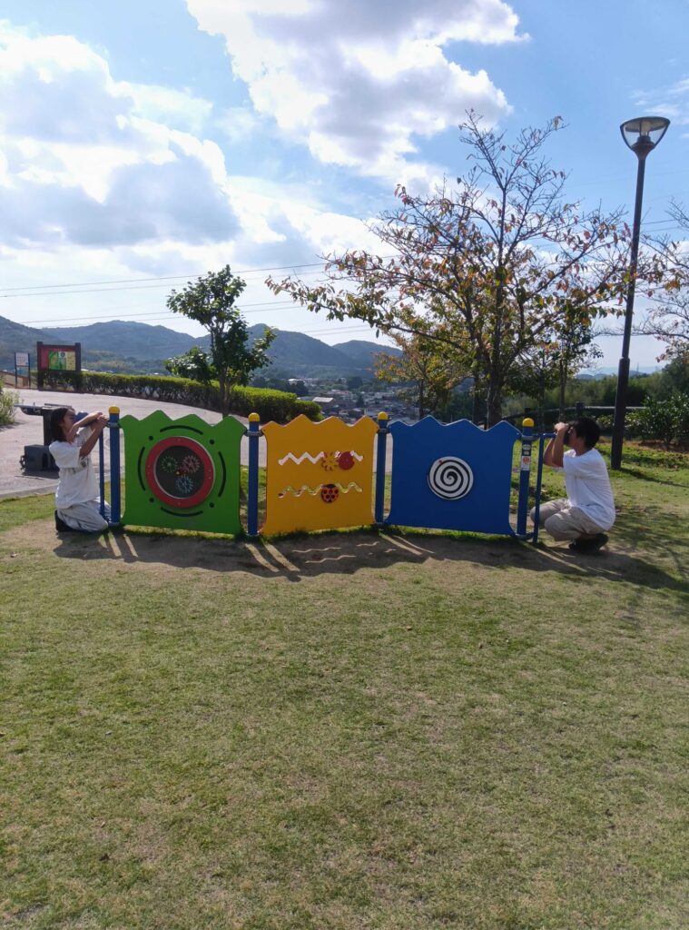 カラフルな遊具の両端に分かれて遊ぶ子どもたち