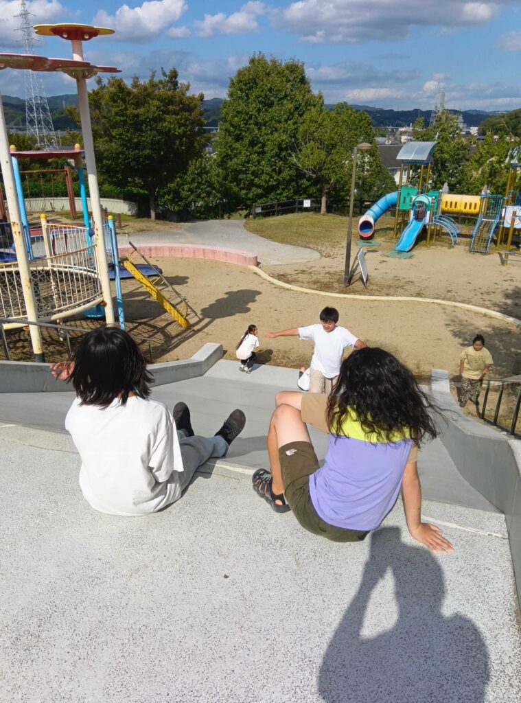 石の滑り台を滑り降りる子どもたち