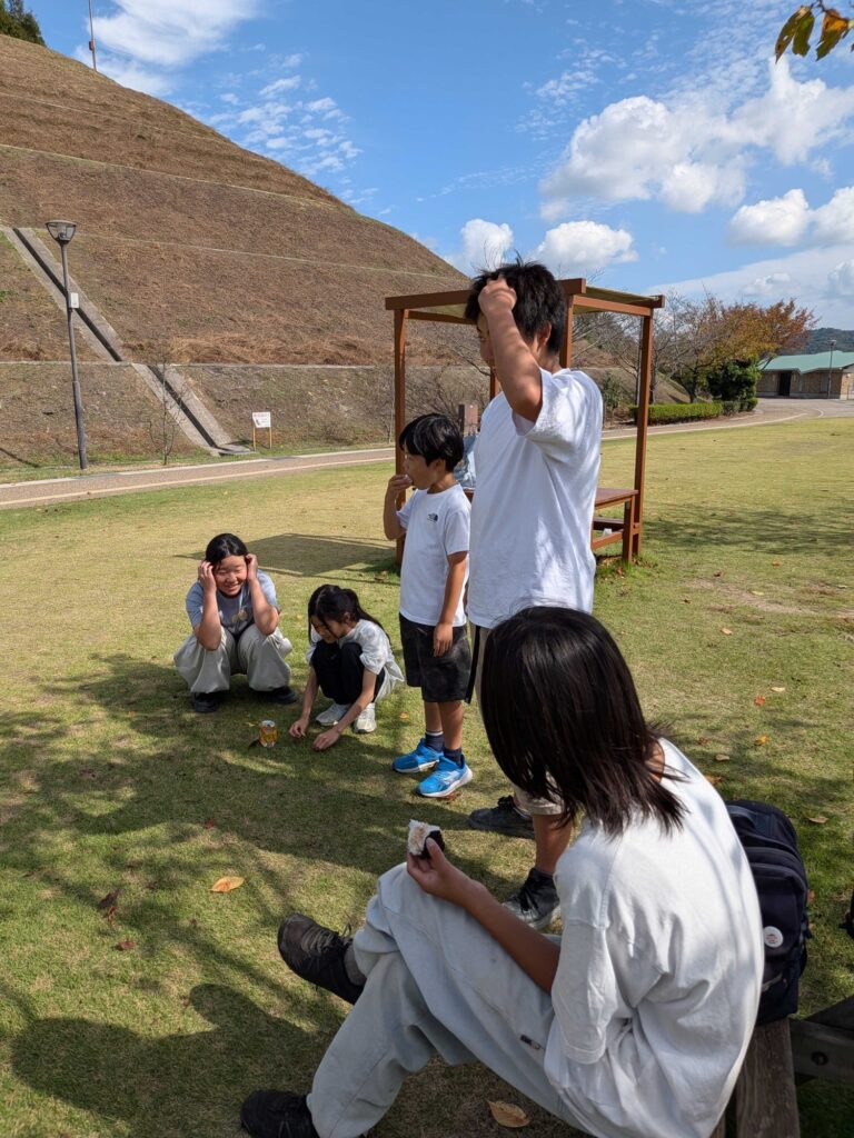 芝生の広場で、お弁当のあとにくつろぐ子どもたち