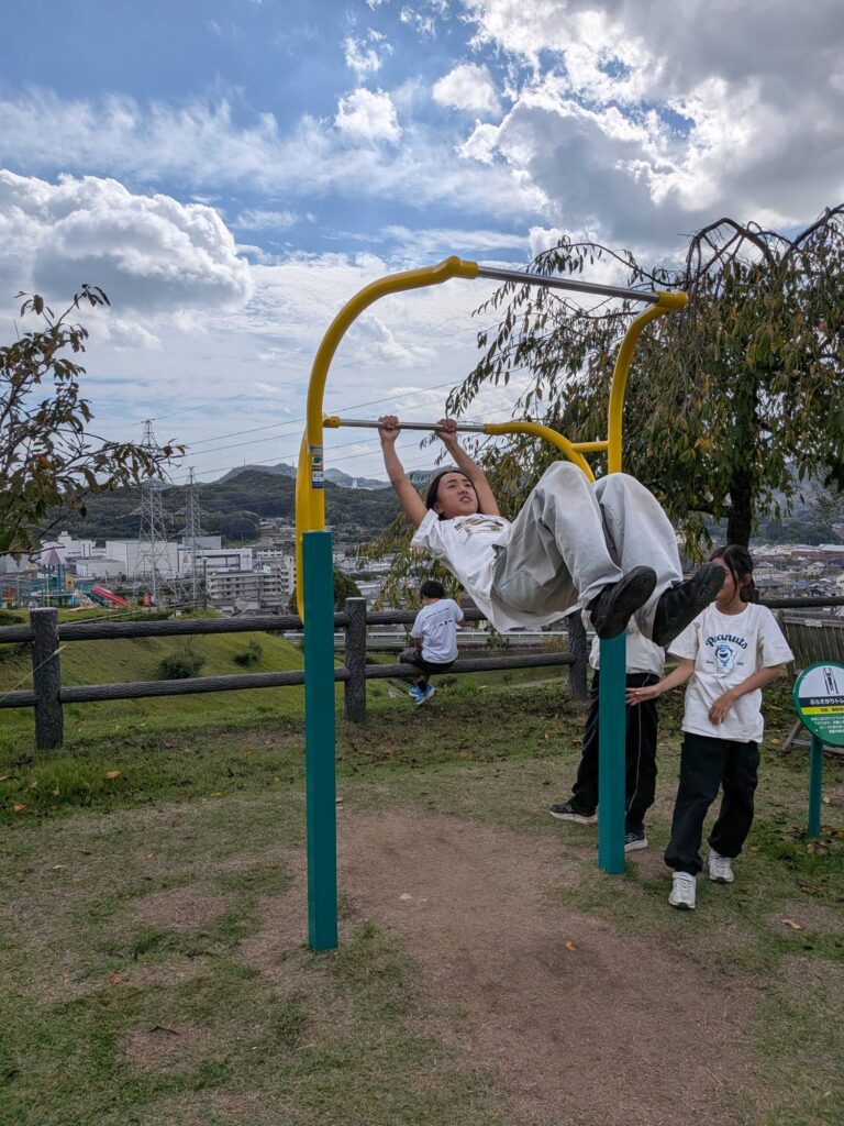 鉄棒で足をかけて回る子ども