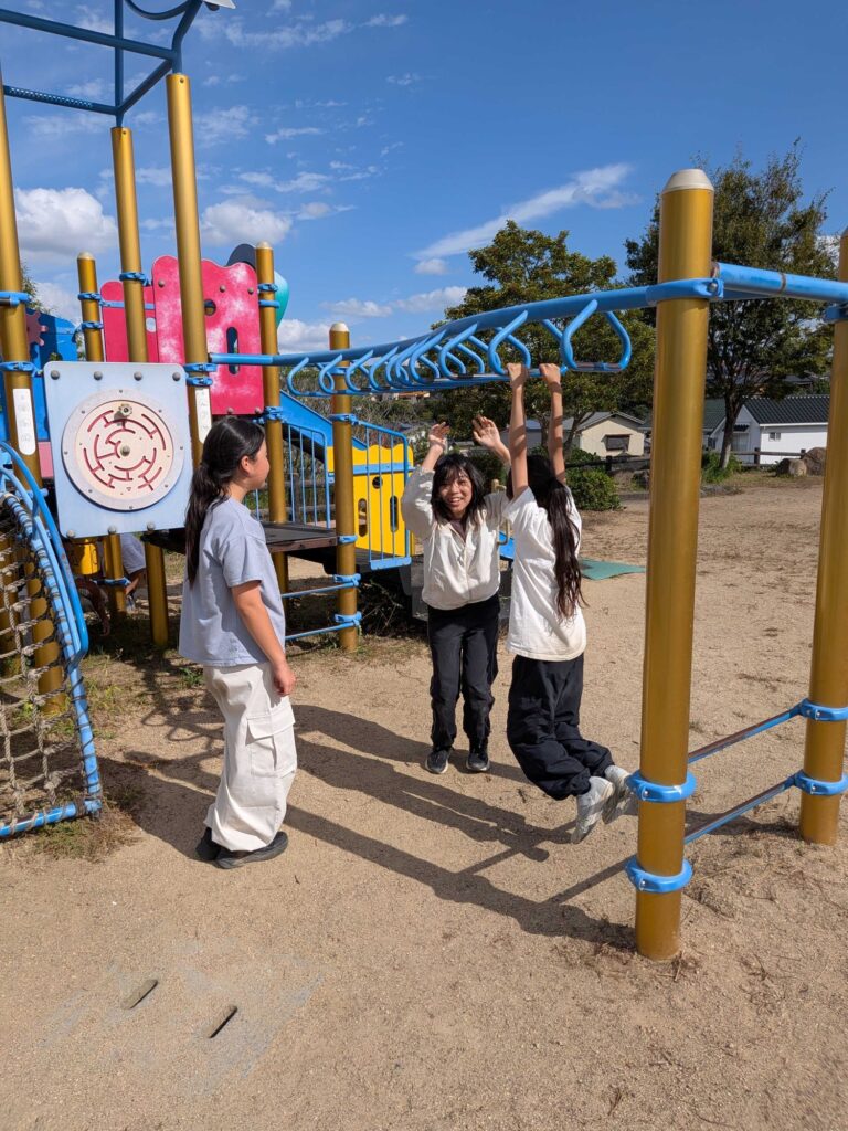 うんていにぶら下がる子どもたち
