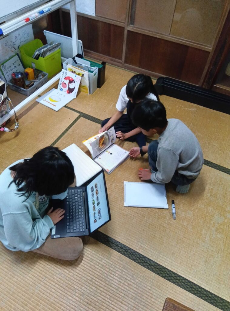 料理の本やパソコンで、料理を調べる子どもたち