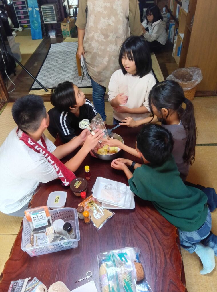 スパイスを並べて、ボウルの鶏肉を混ぜる子どもたち
