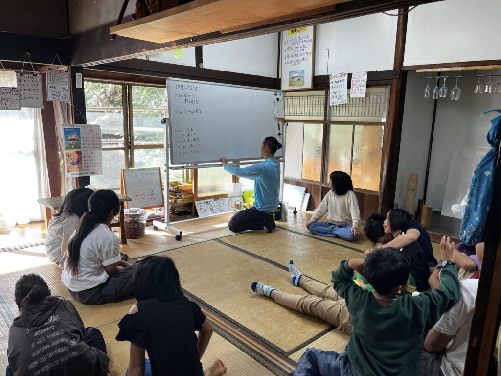 ホワイトボードの前で、スタッフと一緒にスラ読みをする子どもたち