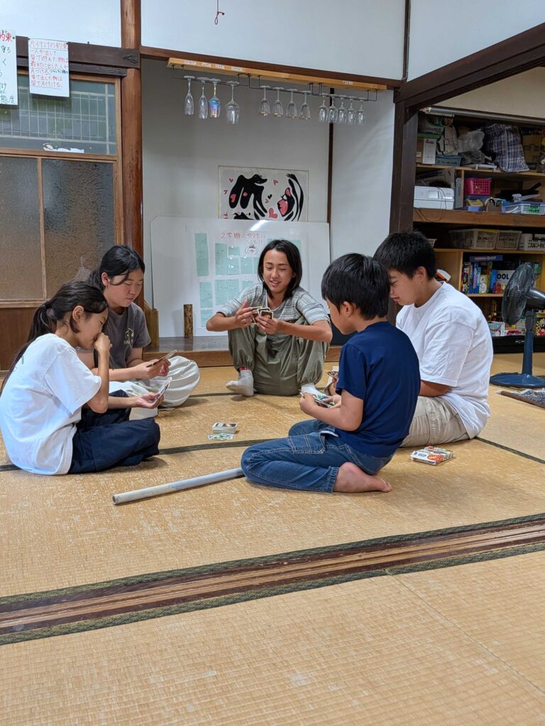畳に座ってカードゲームをする子どもたち